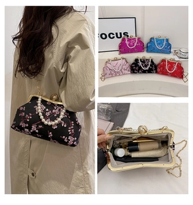 Detail of silk pearl handle bag with floral embroidery and gold chain strap