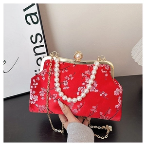 Detail of red satin evening clutch with pink cherry blossom embroidery and pearl chain