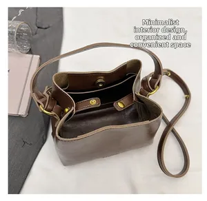 Macro view of retro brown bucket bag showing two main interior compartments and magnetic closure