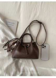 Detailansicht der kaffeebraunen Beuteltasche mit Gürtelschnalle und Hundeanhänger