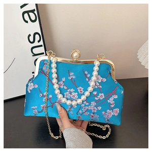 Detail of blue satin evening bag with plum blossom embroidery and pearl handle