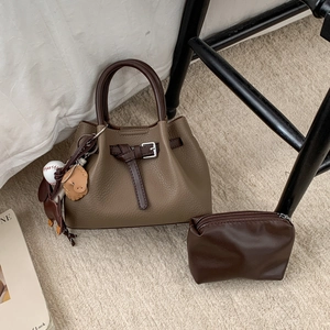 Nahaufnahme der braunen Beuteltasche mit Lychee-Textur und kleinem Reißverschluss-Etui