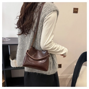 Detail of fashion crossbody bag with embossed lettering and adjustable shoulder strap
