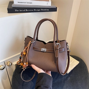 Borsa a mano marrone caffè in finta pelle con chiusura girevole e nappa di perline di legno