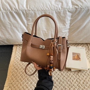 Borsa a mano vintage in pelle scamosciata marrone con ciondolo in legno e tracolla