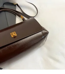 Dettaglio della borsa in pelle lucida testa di moro con fibbia quadrata in metallo dorato