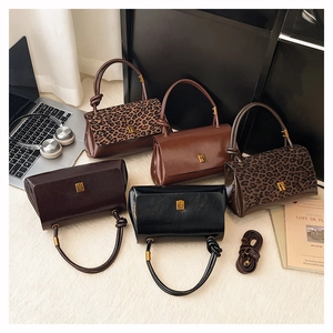 Detail of five assorted leather handbags with leopard prints and metal buckles for women
