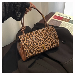 Detail of leopard print faux fur and brown leather handbag with gold twist lock