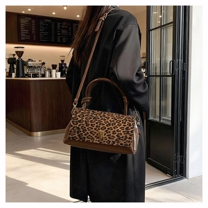 Borsa a tracolla leopardata con chiusura in metallo dorato in un bar alla moda