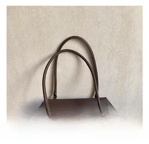 Detail of dark brown lychee grain leather double handles with elegant metal rings