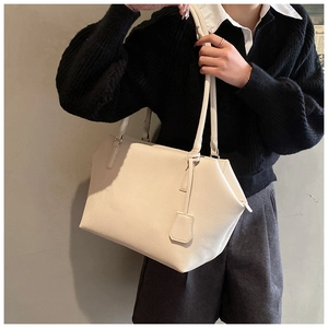 Detail of off-white faux leather tote bag with lychee texture and long shoulder straps