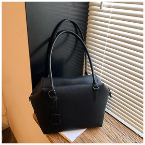 Close-up of black grainy leather tote bag on wooden window sill with soft lighting