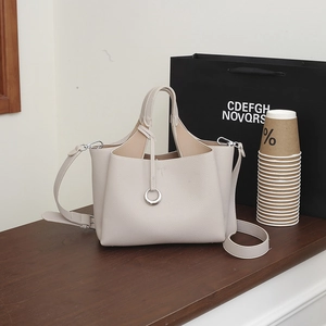 Detailed macro view of litchi texture beige leather handbag with silver ring ornament