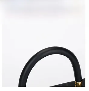 Macro shot of circular black leather handle with premium golden metal fixings