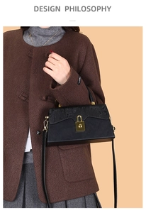 Detailed view of a black leather crossbody box bag featuring elegant gold clasp and slim strap