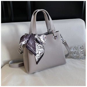 Detail of grey pebbled leather tote bag with elegant silk scarf and detachable strap