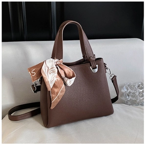 Detail of dark brown tote bag with lychee texture and decorative patterned silk scarf