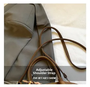 Detailed macro view of the adjustable brown leather shoulder strap and premium hardware hooks