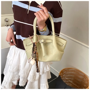 Close-up of light green crossbody bag with lychee texture and coffee cup charm
