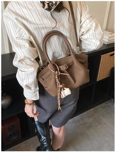 Brown crossbody handbag with leather texture and coffee cup pendant decoration