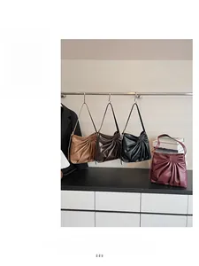 Detail of trendy pleated underarm bags in four colors with artistic ruched leather texture