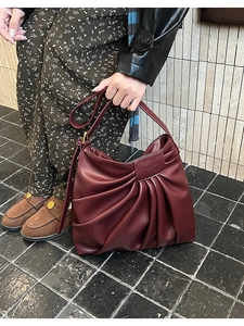 Close-up of retro wine red pleated leather bag with Fashion Bags embossed detail