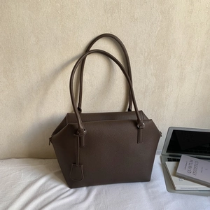 Minimalist large brown tote bag in pebbled leather shown with laptop and books