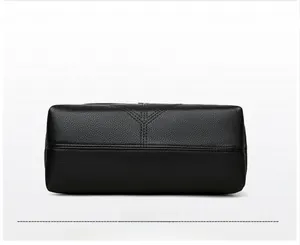 Detailed bottom view of black lychee grain leather tote bag with Y-shaped reinforced stitching