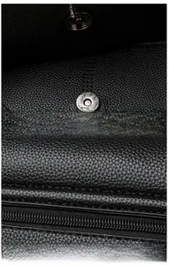 Detail of lychee pattern leather shoulder bag with magnetic metal clasp and neat stitching