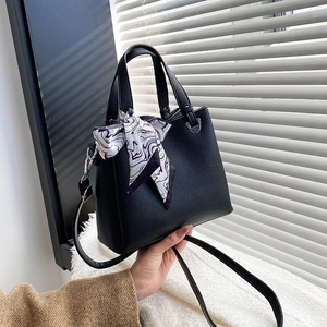 Fashionable black lychee textured handbag with silk scarf detail and crossbody strap