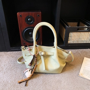 Chic cream green leather handbag with a coffee charm and elegant top handles