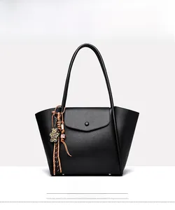 Close-up of black lychee grain leather tote bag with leopard print bear charm