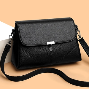 Fashionable black pebbled leather crossbody bag with V-shaped stitching and leaf pendant