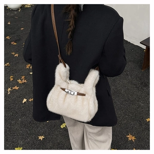 Detail of fuzzy cream crossbody bag with brown leather strap and silver twist lock closure