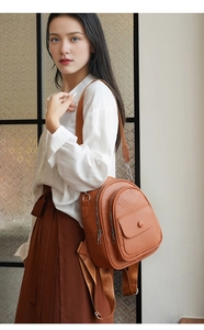 Nahaufnahme brauner Rucksack mit Litschi-Muster und verstellbaren Trägern am weiblichen Model