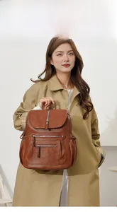 Brown vintage faux leather backpack detail showing front zipper pockets and side drawstrings