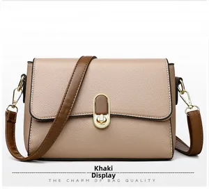 Close-up of the khaki shoulder bag showing the turn-lock closure and leather texture