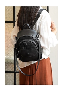 Nahaufnahme des schwarzen Rucksacks mit Lychee-Maserung, Reißverschlüssen und silbernen Beschlägen