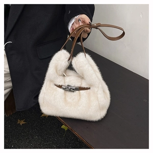 Detail of white faux fur crossbody bag with brown leather strap and silver metal clasp