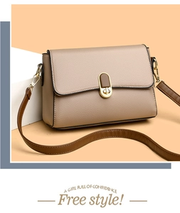 Close-up of khaki pebbled leather bag with gold twist lock and brown strap details