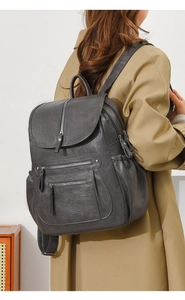 Detail of dark grey leather backpack on model showcasing size and daily casual style