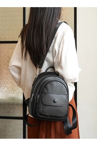 Detail eines schwarzen Lederrucksacks mit V-Steppung und verstellbaren Nylon-Schultergurten