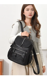 Detail showing high-quality black PU leather texture and silver buckle on a stylish backpack