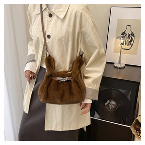 Detail of soft brown plush crossbody bag with silver metal twist lock and leather strap