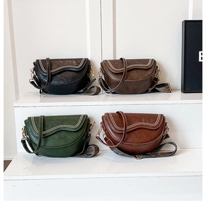 Détails de quatre sacs selle en cuir coloré avec de larges bandoulières à motifs imprimés