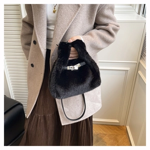 Detail of black faux fur handbag with a silver turn-lock and soft texture close-up