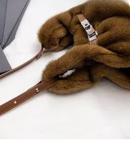 Close-up of caramel faux fur bag with adjustable leather strap and silver metal lock