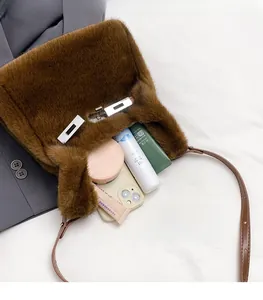Deep brown faux fur handbag interior showing storage capacity for cosmetics and phone