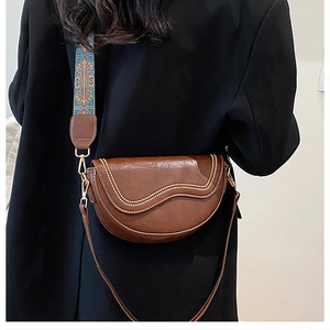 Détail du sac selle marron vintage avec perles dorées et large bandoulière brodée