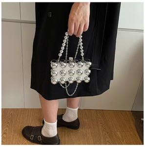 Detail of silver mirror acrylic box bag with 3D studs and metallic chain strap